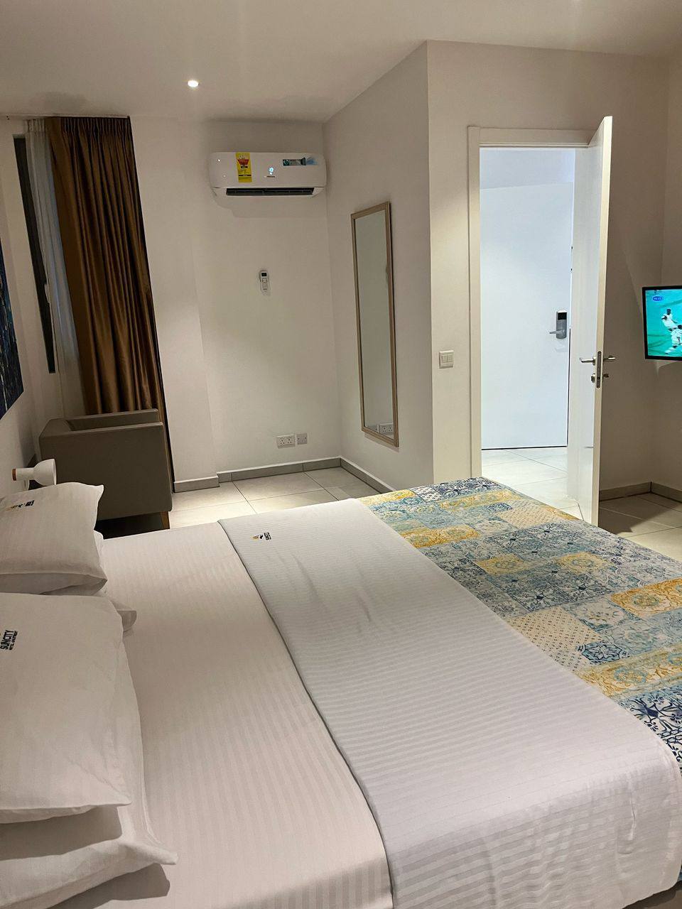 A white bed room with a white wall and a white bed